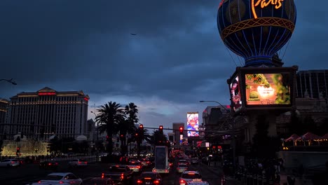 Driving-on-Las-Vegas-Strip-in-Dark-Twilight-Under-Cloudy-Sky,-Traffic-and-Light