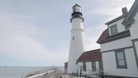 Wunderschöner-Blick-Aus-Der-Nähe-Auf-Den-Leuchtturm-Portland-Maine-Head-An-Einem-Wunderschönen-Frühlingstag-Mit-Wellen,-Die-In-4K-An-Die-Felsige-Küste-Rollen