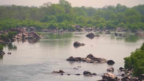 Toma-Panorámica-Del-Río-Betwa-Que-Fluye-A-Través-De-Un-Terreno-Rocoso-En-Las-Orillas-Del-Bosque-Cerca-De-Orchha-En-Madhya-Pradesh,-India