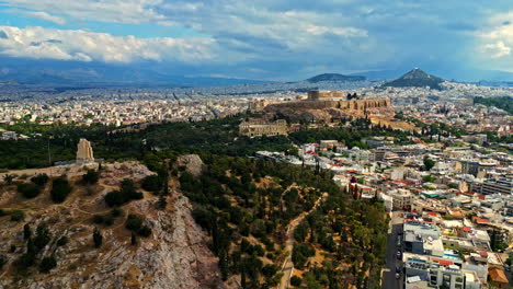 Restos-Antiguos-Y-Vistas-A-La-Ciudad-Con-La-Acrópolis-En-Atenas,-Grecia---Disparo-Aéreo-De-Drones
