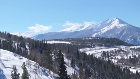 Amazing-winter-landscape-of-snow-capped-Mount-Swan,-forest-and-highway-in-Colorado