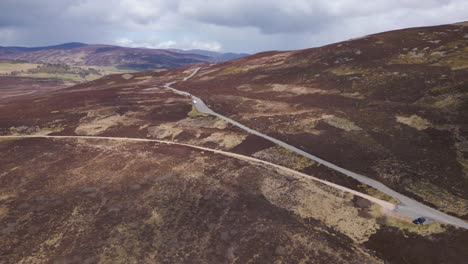 Vuelo-Aéreo-Sobre-Los-Cairngorms,-Coches-Que-Viajan-Por-Carretera,-Escocia