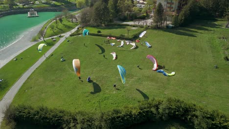 Kitesurfers-on-meadow-along-shores-of-Molveno-Lake,-Trentino-in-Italy