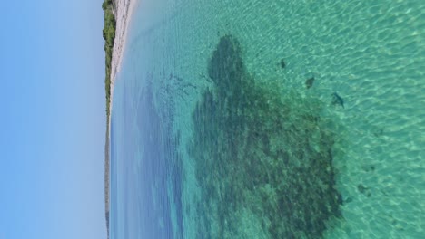 Drone-flying-at-low-altitude-over-shallow-waters-of-playa-La-Cueva-beach-in-Dominican-Republic