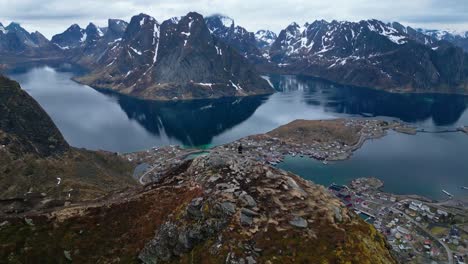 Alejar-Y-Ver-Panorámica-Del-Hombre-En-El-Borde-De-La-Colina-En-Reinebringen,-Noruega