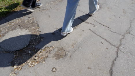 People-walking-on-terrible-condition-asphalt-sidewalk,-city-problems
