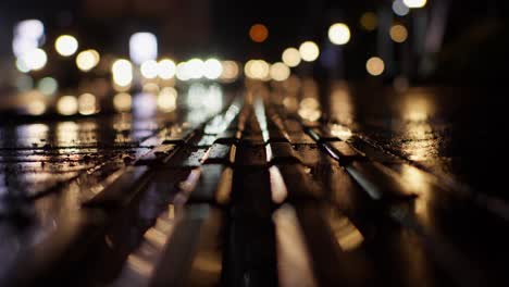 Blurred-View-Of-Cars-Traffic-and-Lights-Along-Wet-Urban-Street-Road-At-Night