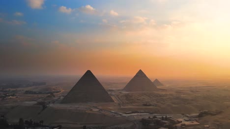 Aerial-of-sunset-view-over-the-Great-Pyramids-of-Giza,-on-the-Pyramids-Plateau-in-Egypt,-embodies-the-concept-of-timeless-grandeur-and-majesty