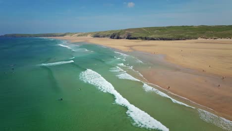 Perranporth-Beach-Surfers-Riding-Turquoise-Waves-Along-the-Stunning-Cornish-Coastline,-UK