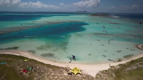 Vibrant-kite-surfers-at-cayo-vapor,-los-roques,-venezuela,-aerial-view