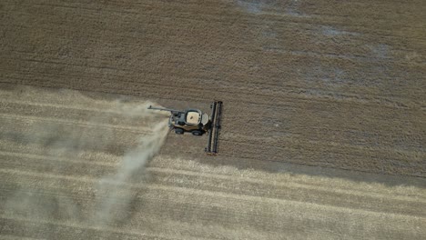 Tractor-harvesting-grain.-Aerial-tilt-down-forward