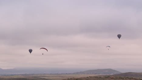 Temecula-Balloon-and-Wine-Festival-Two-Hot-Air-Balloons-With-Two-Paragliders-Shot-by-Drone