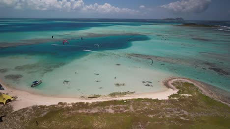 Kite-surfers-at-cayo-vapor-in-los-roques,-venezuela-with-vibrant-turquoise-waters,-aerial-view