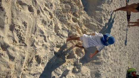 Zeitlupe-Eines-Kleinen-Mexikanischen-Lateinamerikanischen-Jungen-Mit-Weißem-T-Shirt-Und-Blauem-Hut,-Der-Auf-Dem-Sand-An-Einem-Strand-In-Cancun,-Mexiko,-Läuft