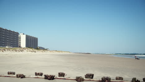 Pan-Toward-Relaxed-Man-Fishing-on-Jersey-Shore-near-Condos