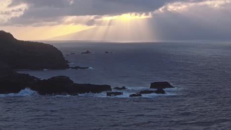 Sun-rays-breaking-through-clouds-over-the-North-West-shore-of-Maui,-Hawaii-at-sunrise