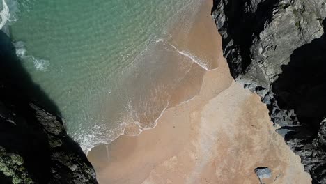 Cornish-Beach-Cove-in-Cornwall-with-Turquoise-Waters,-Slow-Motion-with-Top-Down-View-from-Drone,-UK