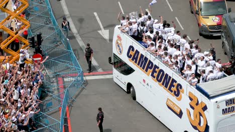 Real-Madrid-players-riding-on-a-bus-to-celebrate-winning-the-36th-Spanish-soccer-league-championship,-the-La-Liga-title-trophy,-at-Cibeles-Square,-where-thousands-of-fans-gathered-in-Madrid