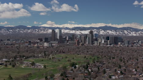 City-Park-Golf-Course-Downtown-Denver-Colorado-aerial-drone-Spring-Mount-Blue-Sky-Evans-Front-Range-Rocky-Mountains-foothills-skyscrapers-neighborhood-streets-Ferril-Lake-daytime-sunny-clouds-up-jib