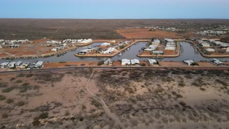 Drone-aerial-of-houses-on-a-river-harbour-in-exmouth-surrounded-by-a-vast-landscape