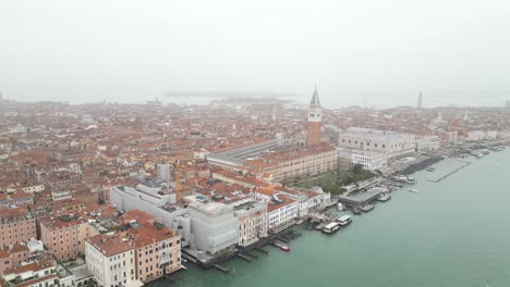 Venice-Italy-aerial-on-foggy-day-as-boat-pulls-out-of-canal