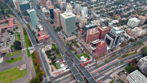 Aerial-view-establishing-the-Escuela-Militar-sector,-affluent-area-of-Santiago-de-Chile-with-the-SCL-Apoquindo-building,-main-street-of-Las-Condes
