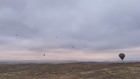 Temecula-Ballon--Und-Weinfest,-Fünf-Ballons,-Zwei-Gleitschirmflieger,-Der-Nächste-Ballon-Schießt-Feuer,-Um-An-Höhe-Zu-Gewinnen,-Drohnenaufnahmen