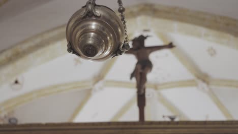 Cinematic-Tracking-Rack-Shot-Beginning-Focused-On-Censer-Then-Shifts-Focus-To-Crucifix-In-The-Background