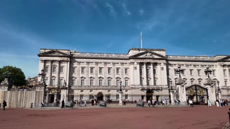 Front-view-of-Buckingham-Palace,-with-visitors-gathered-in-front-on-sunny-morning