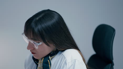 Beautiful-young-woman-with-long-dark-hair-wearing-glasses-concentrating-at-the-work-in-office-in-slow-motion