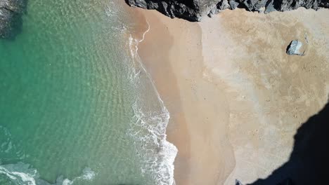 Beautiful-Beach-Cove-with-Tranquil-Waters-in-Slow-Motion,-Aerial-Ascending-Drone-in-Cornwall,-UK