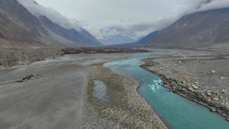 Aerial-View-Of-Hunza-River-Flowing-Through-Nomal-Valley-Landscape-In-Gilgit