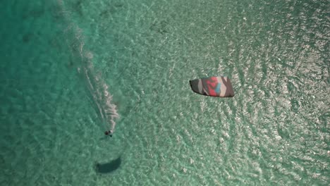 Drone-aerial-view-of-a-kiter-surfing-on-a-turquoise-sea