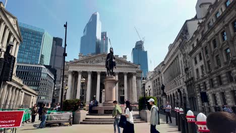 Statue-in-front-of-The-Royal-Exchange-with-modern-buildings-in-the-background,-London,-sunny-day