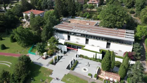 Stunning-aerial-of-the-Olympic-Museum-in-Lausanne,-Switzerland-on-a-sunny-summer-day