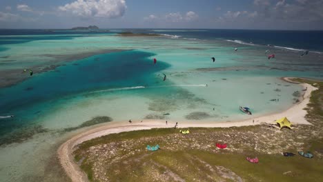 Kite-surfers-on-vapor-cay-in-los-roques,-venezuela-with-vivid-blue-waters,-aerial-view