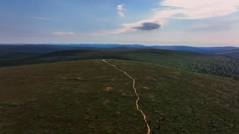 Drone-following-a-trail-on-top-of-tunturi-mountains-of-UKK-national-park,-in-Finland