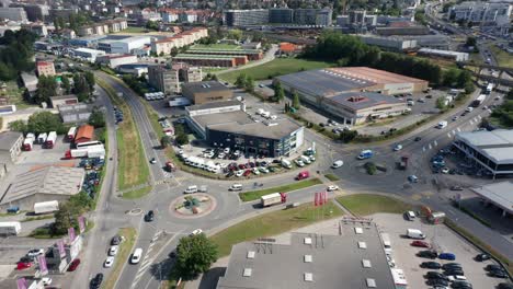 High-angle-view-of-busy-industrial-site-with-cars-and-trucks-driving-over-road-and-roundabout