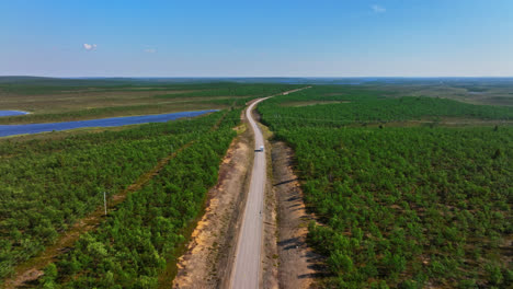 RV-driving-in-middle-of-Kevo-and-Kaldoaivi-wilderness-nature,-summer-in-Lapland---Aerial-view