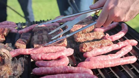 Gente-Asando-Salchichas-En-La-Parrilla-Usando-Tenedor-Y-Pinzas