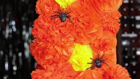 Putting-plastic-spiders-on-cempasuchil-flower-garland-for-Halloween