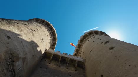 Castle-filmed-down-to-the-top-overlooking-a-sunny-day-with-a-Spanish-flag-waving-on-the-top-of-the-castle