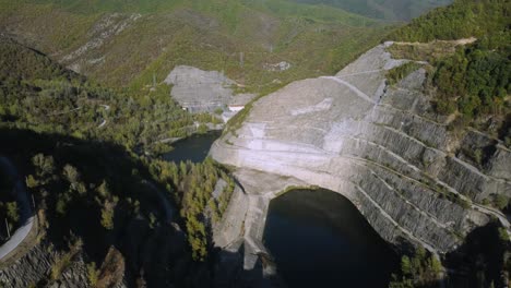 Aerial-establishing-of-large-dam-in-the-mountains-in-spring