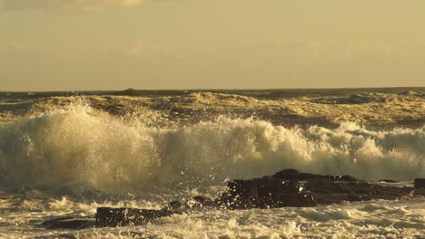 Rough-Sea-Waves-Crashing-On-Rocky-Shoreline-Creating-Huge-Spray-During-Golden-Sunset---Medium-Static