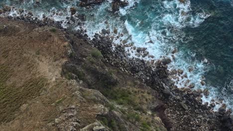 Maui's-rugged-north-west-shore-with-waves-crashing-against-rocky-cliffs,-aerial-view