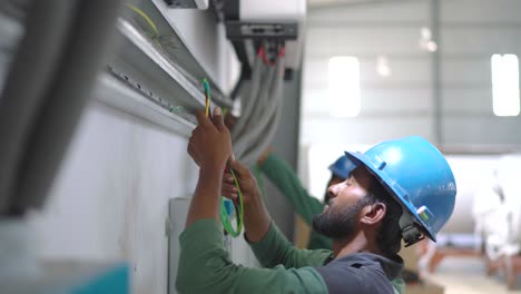 Ingeniero-Eléctrico-Colocando-Cables-En-Conductos-En-Una-Fábrica-En-Pakistán