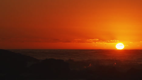 Goldener-Sonnenuntergang-über-Rauen-Meereswellen,-Während-Vögel-Durch-Den-Rahmen-Fliegen-–-Statische-Aufnahme