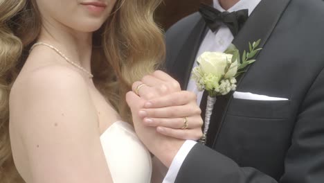 Newlyweds-are-holding-hands-and-showing-wedding-rings