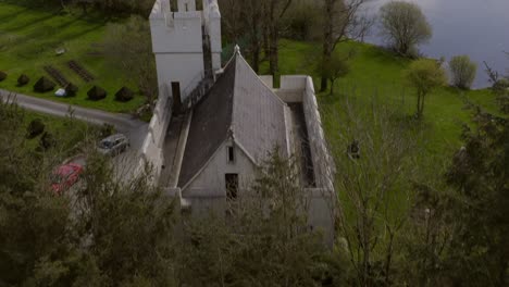 Dense-green-tree-canopy-behind-edge-of-fortified-castle-home-in-countryside