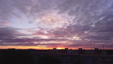 Drone-video-of-sunset-and-fluffy-clouds,-over-the-buildings-in-Prague